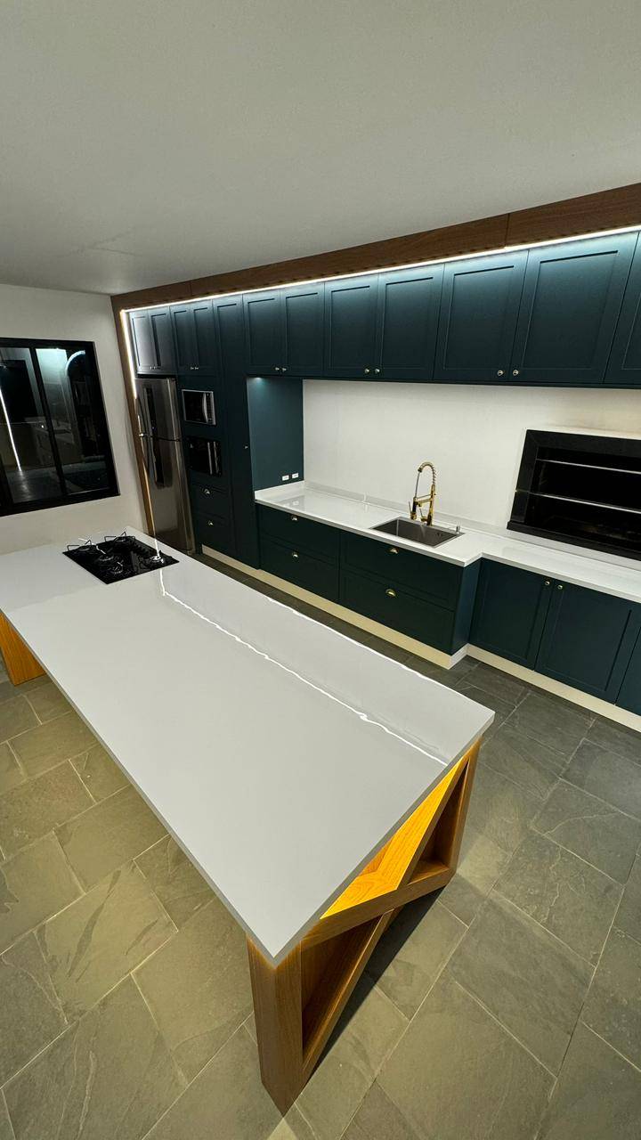 Área gourmet com churrasqueira revestida e marcenaria escura.